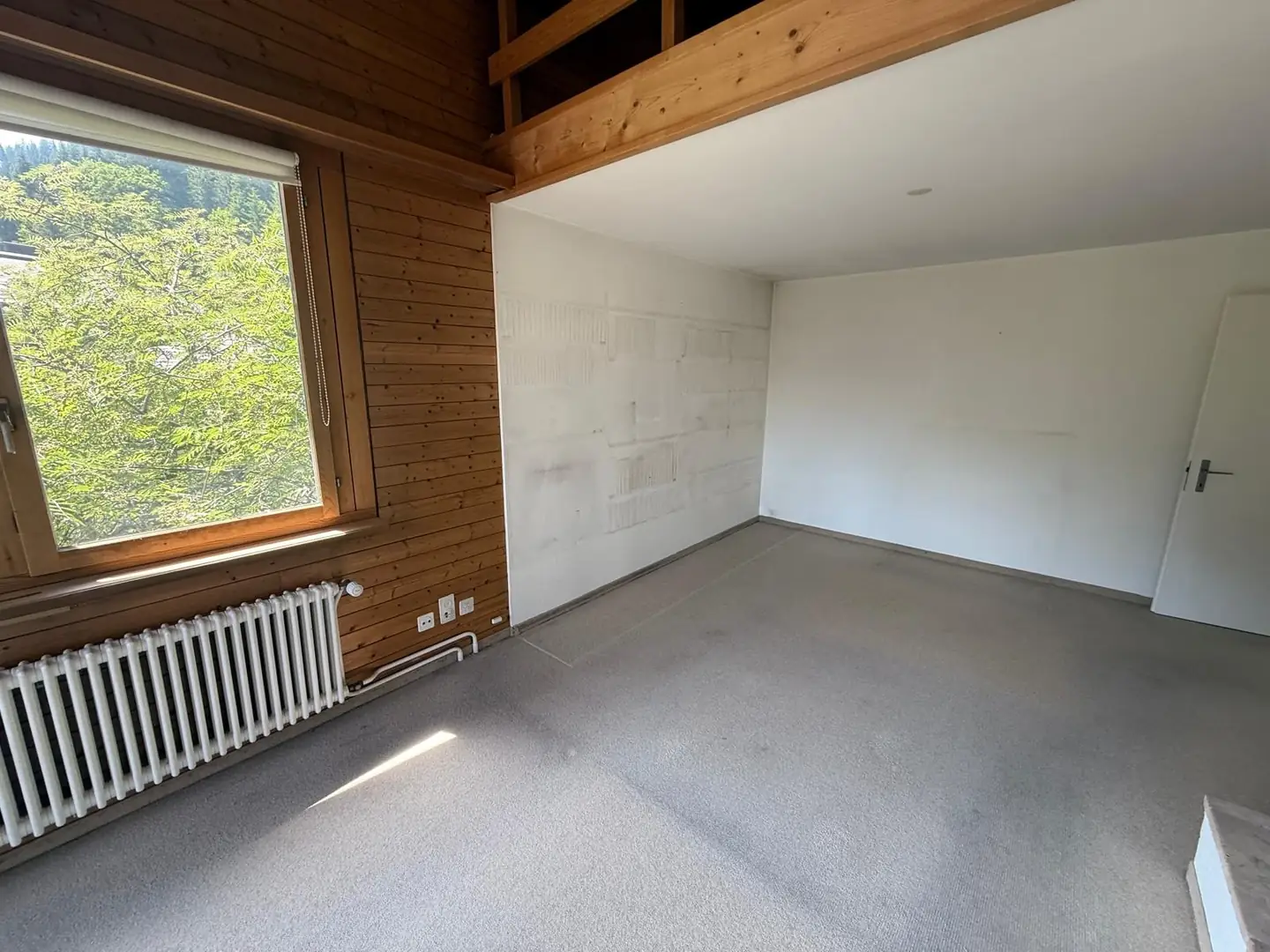 Leer geräumter Wohnraum mit Holzverkleidung